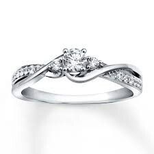 a white gold engagement ring with two diamonds on the band and an intertwined design