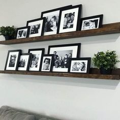 two wooden shelves with pictures and plants on them