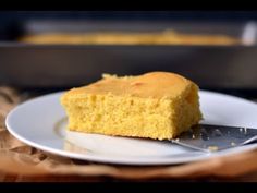 a piece of cornbread sitting on top of a white plate next to a spatula