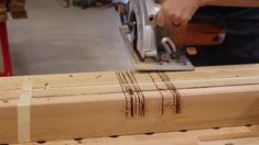 a person using a circular saw to cut wooden planks with an electric planer