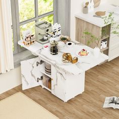 an aerial view of a kitchen and dining room with wood flooring, white cabinets and appliances