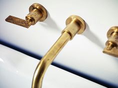 two brass handles on the side of a white toilet