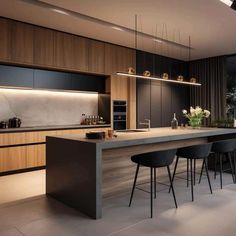 a modern kitchen with an island counter and bar stools in the middle of it