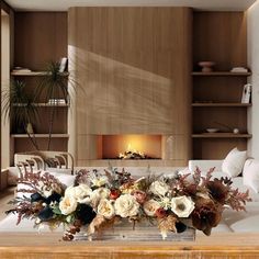 a living room filled with lots of furniture and flowers on top of a coffee table