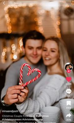 a man and woman holding up a candy cane