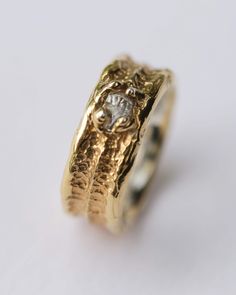 This thick ring has wide silver band that is pleated in yellow gold and a small raw Herkimer diamond stone in it. The band is uneven in design to remind something from old ages. Gold plated (24 carat) silver ring with raw Herkimer diamond quartz. This ring of your chosen size will be custom made. It can take up to 2 weeks before sending the ring to you, but I will do my best to get your ring done sooner. GLASSWOLF GlassWolf is a brand of distinction. Jewelry bought from GlassWolf is jewelry that is handcrafted with respect to nature and its creations. CUSTOM MADE ORDERS: If you wish to make custom ordered ring - its possible. Only you have to keep in mind that custom order can have different price depending on your desires and the rings for custom order can be of size US 5 till US 15. It c Raw Gold Ring, Herkimer Diamond Ring Engagement, Ring Redesign, Wide Silver Band, Cute Engagement Rings, Thick Ring, Wide Band Ring, Celtic Style, Ringe Gold