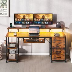 two computer monitors sitting on top of a wooden desk in front of a white couch