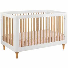 a white crib with wood trim on the sides