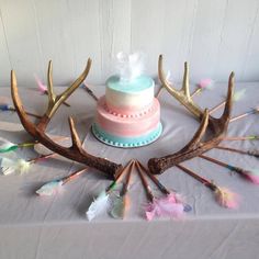 a cake decorated with antlers and feathers on a table