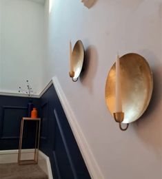 three gold plates mounted to the side of a wall next to a blue and white hallway