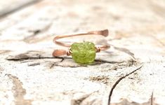 💚Raw and natural tiny peridot stone in adjustable dainty 18g gold or silver ring band with hand hammered ends. Perfect dainty little ring that can fit any fingers of your choice. 💚Peridot - An August birthstone. This gift from the heart of Mother Nature comes with a ton of healing properties. Deep-set calm, good health, restful slumbering, and restoring balance and harmony to the body, mind and soul are just a handful of things you can expect when you say yes to Peridot. Ring size- Fits 5-8 ad Minimalist Adjustable Rings With Raw Stone, Adjustable Green Crystal Gemstone Ring, Adjustable Green Crystal Dainty Ring, Adjustable Green Crystal Ring For Promise, Adjustable Green Crystal Promise Ring, Green Birthstone Ring For Promise, Adjustable Green Dainty Rings, Unique Adjustable Green Stackable Rings, Adjustable Green Stackable Crystal Ring