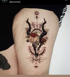 a woman's thigh with an artistic tattoo design on it and flowers in the center