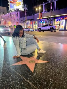 a woman sitting on the hollywood walk of fame