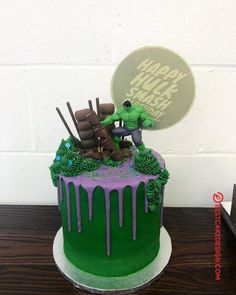 a green and purple cake with the hulk on top