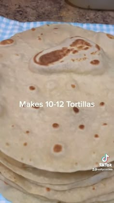 a stack of tortillas sitting on top of a blue and white checkered table cloth