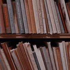 a book shelf filled with lots of books next to each other on top of wooden shelves