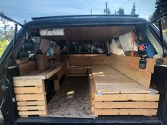 the back end of a van with wooden pallets in the cargo area and seats folded down