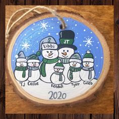 a wooden ornament with snowmen on it