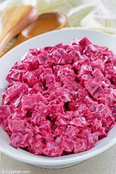 a white bowl filled with red food on top of a table