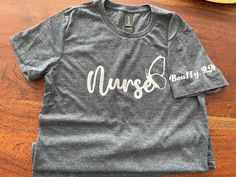 Nurse T-Shirt, shortsleeve, 100% Cotton high quality Gildan T-Shirt, fitted soft-style. Customizable with your name on the sleeve if desired.  Sizes S-XL available. PM me for color options. Fitted Short Sleeve T-shirt With Custom Print, Gray Fitted Crew Neck T-shirt, Fitted Crew Neck T-shirt With Custom Print, Gray Short Sleeve T-shirt With Letter Print, Fitted Short Sleeve T-shirt With Letter Print, Fitted Basic Pre-shrunk T-shirt, Fitted Graphic Tee With Name Print, Unisex Gray Short Sleeve T-shirt, Fitted Gray Graphic Tee