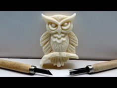 an owl carving next to two sharp knives