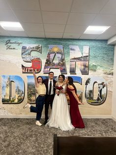 three people posing for a photo in front of a wall with the words las vegas