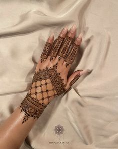 a woman's hand with henna on top of it and the bottom half of her arm