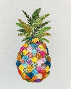 an embroidered pineapple with colorful flowers and leaves