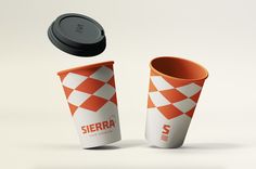 an orange and white checkered cup with lid next to a black plastic cup that says sierra