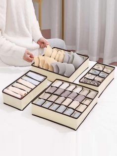 a woman is sitting at a table with several pairs of socks in the trays