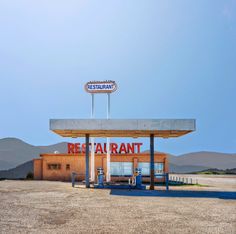 an empty gas station with a sign on top that says restaurant in front of it