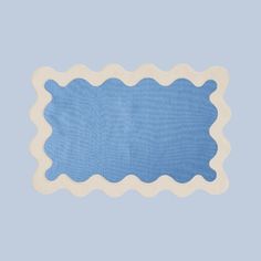 a blue and white placemat with scalloped edges on a light blue background