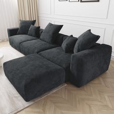 a large black couch sitting on top of a wooden floor