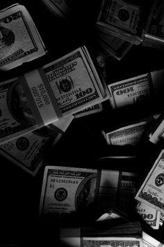 black and white photograph of dollar bills falling from the sky to the ground in front of them