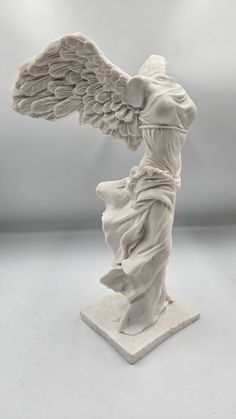 an angel statue is shown on a white surface