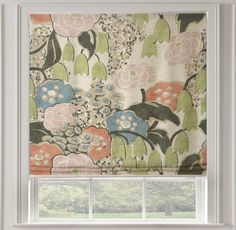 a window with a flowered roman blind in front of it