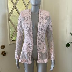 Lovely and versatile sheer pale pink mesh jacket with lace appliques' and scattered clear rhinestones. Long sleeves, open front, hip length. Has shoulder pads which can be easily removed. Measurements are 34" bust, 29" waist, 42" hips, 26" length, 24" sleeve length; this can fit a size small to medium due to the open front. Glam up a sweet little slip dress or toss over a tank top and jeans for a more casual look! Very good vintage condition. Sheer Long Sleeve Party Outerwear, Spring Party Outerwear With Sheer Sleeves, Spring Sheer Party Outerwear, Spring Party Sheer Outerwear, Sheer Outerwear For Spring Party, Pink Embellished Spring Outerwear, Fitted Spring Outerwear With Sheer Sleeves, Spring Fitted Outerwear With Sheer Sleeves, Fitted Lace Trim Outerwear For Spring