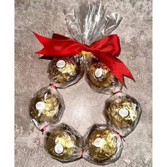 four wine balls wrapped in cellophane and tied with a red ribbon around them