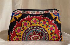 a colorful embroidered purse sitting on top of a table