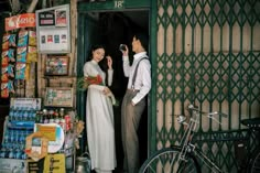 a man and woman standing in front of a store