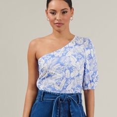 Bloom Into Beauty With The Azul Tropical One Shoulder Blouse! This Airy Top Has An Allover Floral Print, In Shades Of White And Blue, That Covers The One-Shoulder Neckline, The Single Half Sleeve With An Elasticized Cuff. You Can Wear It Tucked In Or Out Any Shorts With Heels! - One Shoulder - Puff Sleeve - Zipper - Blouse - Color: Blue Size + Fit - Model Is 5'8" And Wearing Size Xs - Measurements Taken From Size S - Chest: 17" - Length: 23 1/2" Self:100% Cotton Lining:97% Polyester 3% Spandex Tops Azul, Shorts With Heels, Zipper Blouse, Short Heels, Blue Floral Blouse, Tropical Blue, Shades Of White, Puff Sleeve Top, Half Sleeve