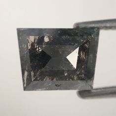 an unhealthy diamond is being held up in the air by a pair of tongs