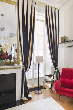 a living room filled with furniture and a fire place next to a window covered in curtains