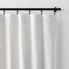 a white curtain hanging from a metal rod