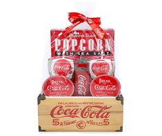 a wooden box filled with coca - colas and wrapped in red ribbon, sitting on top of a white background