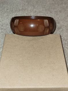 "I will combine shipping on all purchases and refund any overages after shipping fees and insurance. In good vintage condition. Genuine bakelite. Approximately 7.75\" inside. This is a light milk chocolate color that has carved cross looking designs all the way around it. Please look at the pictures for details and condition or message me with any questions" Brown Bakelite Bangle Bracelet, Retro Brown Bracelets As Gift, Brown Bakelite Jewelry Gift, Brown Bakelite Jewelry As A Gift, Brown Carved Bangle Bracelets, Vintage Carved Brown Bracelets, Vintage Brown Carved Bracelets, Adjustable Brown Vintage Bangle, Vintage Brown Bangle As A Gift