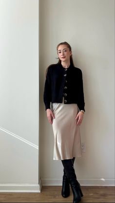 Office/Workwear Outfit Idea. I’m styling a cream silk midi skirt, black cardigan, tall black boots, black belt, and gold jewelry.