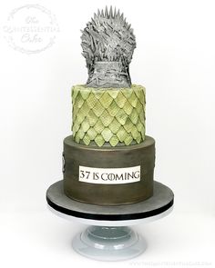 a game of throne cake with the name is coming on it's top tier