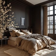 a large bed sitting in a bedroom next to a tall vase with flowers on it