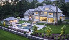 an aerial view of a large house with a pool in the front yard and landscaping around it